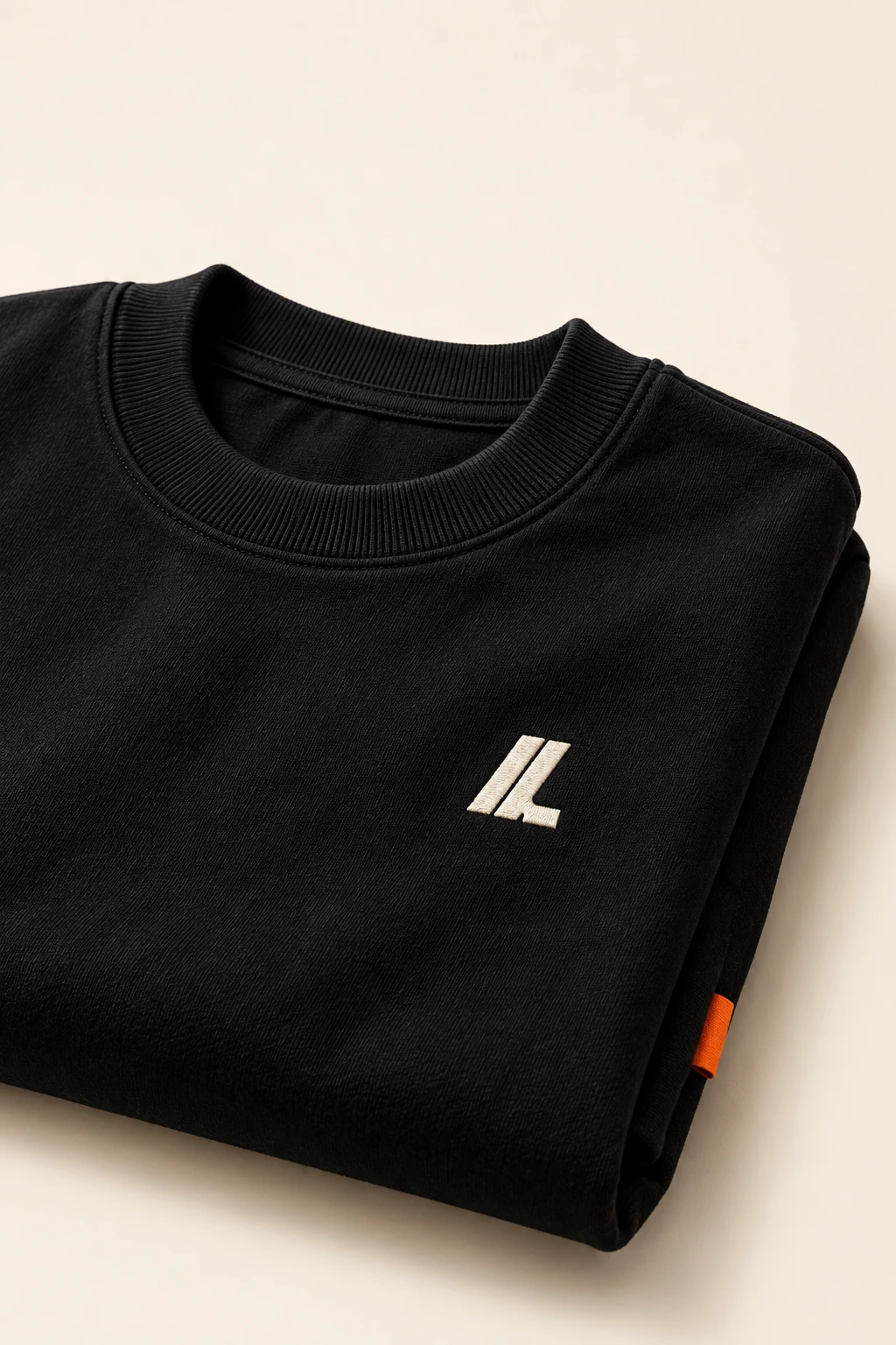 The small Lyverne chest logo and black tee fabric up close